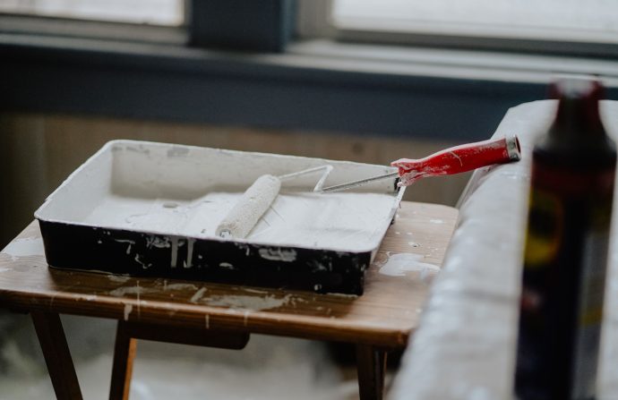 A paint roller and tray with white paint on a wooden table, indicating a renovation work. — Antivirus For Google android - Wo