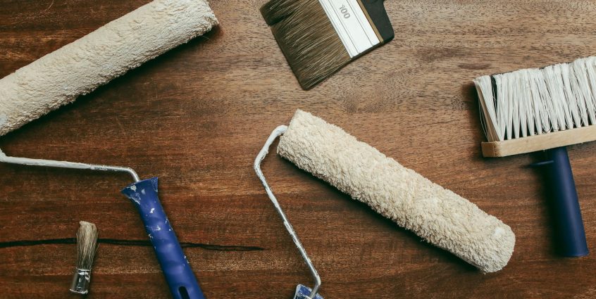 Top view of various painting tools including rollers and brushes laid out on a wooden surface. — Are Online Dating Sites a Go