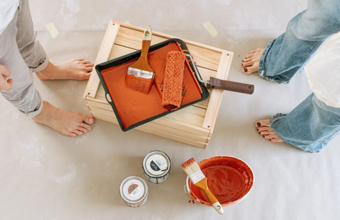 Overhead view of a renovation setup with paint, brushes, and bare feet. — Do you ever Ignore the Warning Flags?