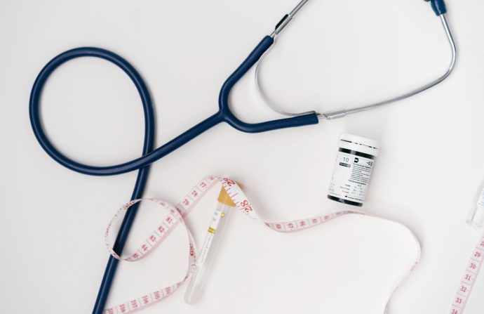 Flat lay of medical tools including stethoscope and measuring tape on a white background. — Explore Wellness Programs Within
