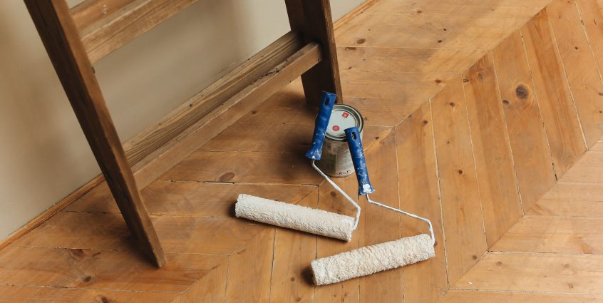 Paint rollers and ladder on a wooden floor, perfect for DIY renovation projects. — How to Get the Best Essay Writing Services