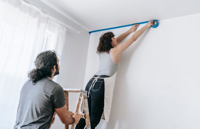 A couple collaborates to tape and paint a room during a home improvement project. — Protected Software For Business