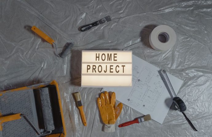 Flat lay of home improvement setup with tools, gloves, and floor plan for DIY projects. — Strains for the Biotech Industry