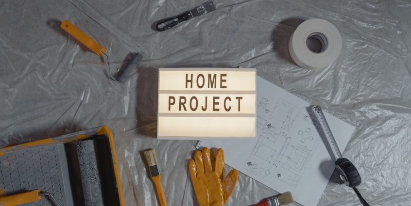 Flat lay of home improvement setup with tools, gloves, and floor plan for DIY projects. — Strains for the Biotech Industry
