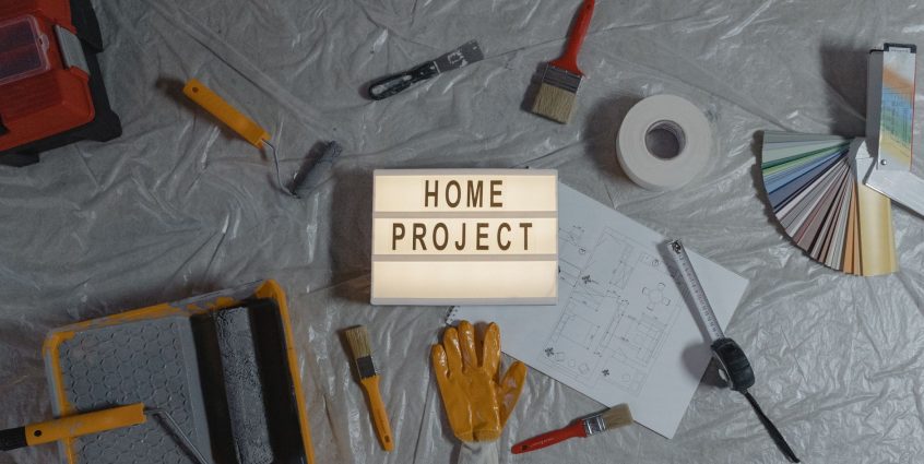 Flat lay of home improvement tools, paint samples, and blueprints for a DIY project. — The Benefits and Risks of Overseas Dir