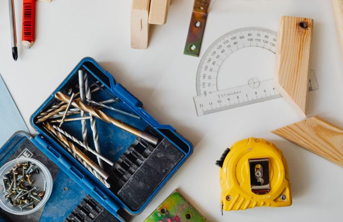 A selection of carpentry tools including drill bits, measuring tape, and protractor in an overhead shot. — What Is an Researc