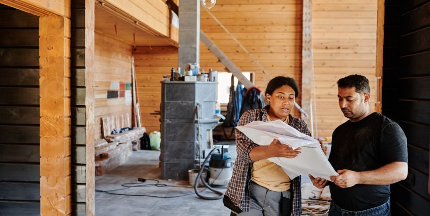 Construction workers reviewing blueprints indoors at a renovation site with wooden walls. — What to Look For in a Top rated A